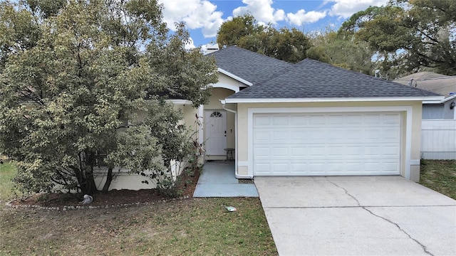 view of front of home with driveway, a shingled roof, and an attached garage