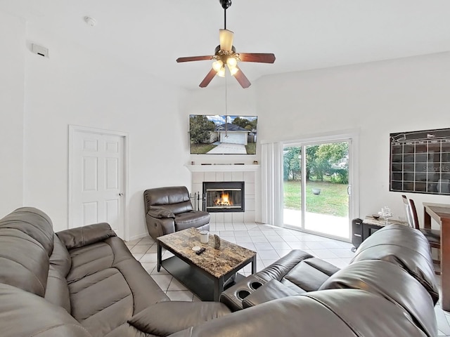 living area featuring light tile patterned floors, ceiling fan, and a tile fireplace