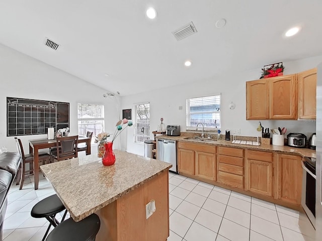 kitchen with light tile patterned flooring, a sink, visible vents, appliances with stainless steel finishes, and a center island