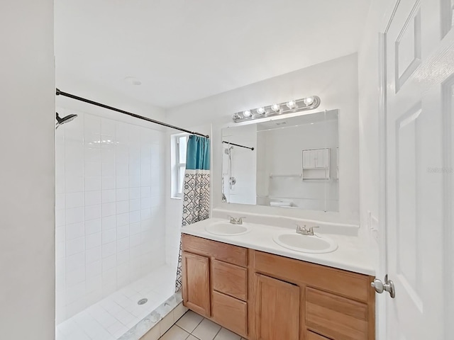 full bathroom featuring double vanity, tile patterned flooring, a sink, and tiled shower