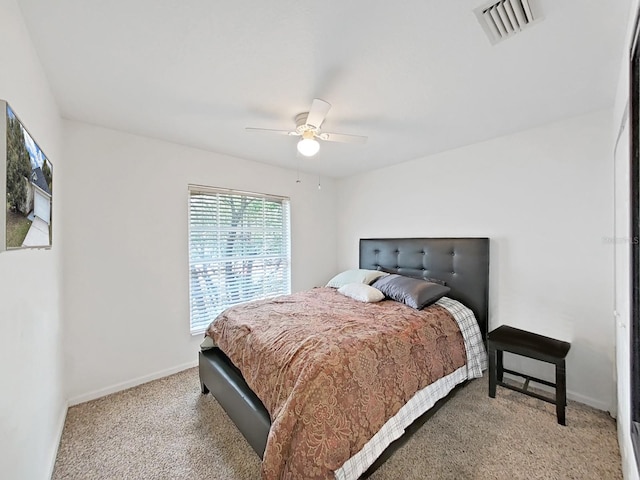 bedroom featuring a ceiling fan, light colored carpet, visible vents, and baseboards