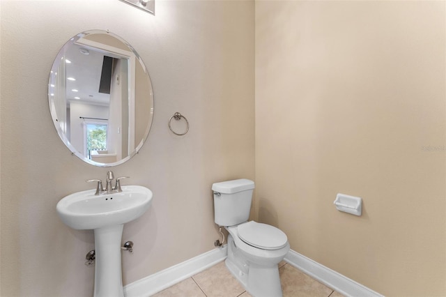 bathroom with tile patterned flooring, toilet, and baseboards