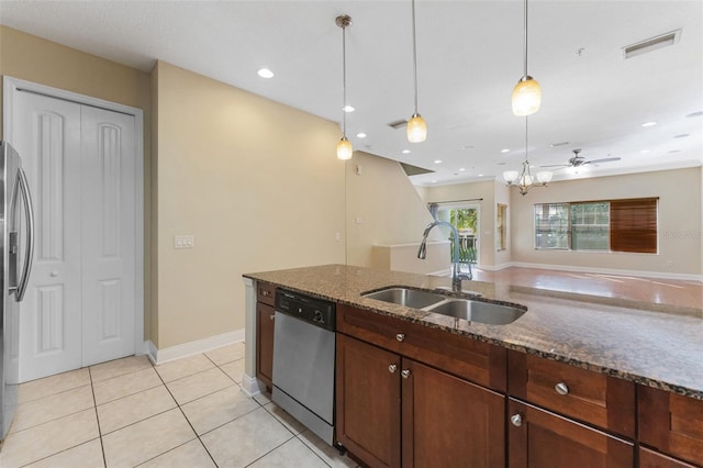 kitchen featuring pendant lighting, stainless steel appliances, visible vents, a sink, and dark stone countertops