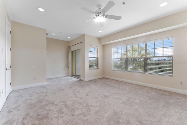 unfurnished room with ceiling fan, baseboards, light colored carpet, and recessed lighting