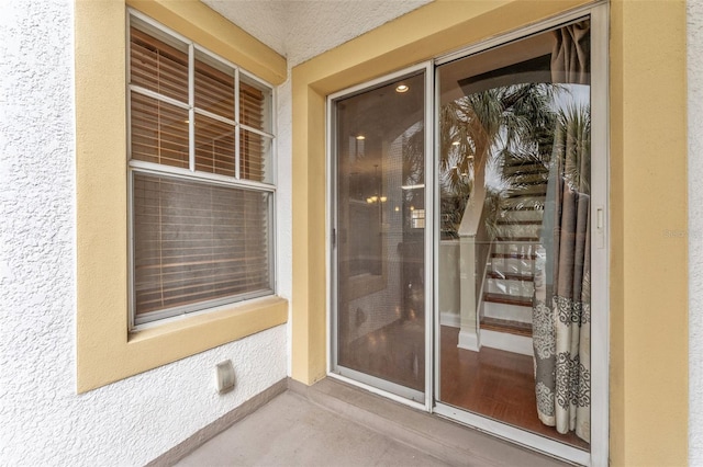 entrance to property featuring stucco siding