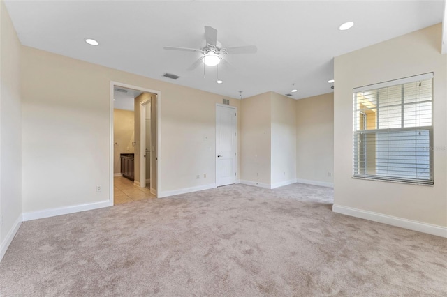 spare room featuring recessed lighting, visible vents, light carpet, and baseboards