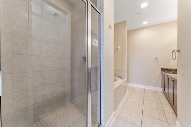 bathroom with a shower stall, vanity, a bath, and tile patterned floors