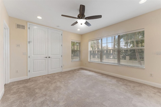 unfurnished bedroom featuring baseboards, visible vents, a closet, and light colored carpet