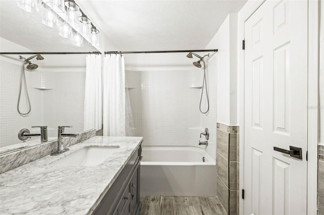 bathroom with shower / bath combo with shower curtain, a textured ceiling, vanity, and wood finished floors