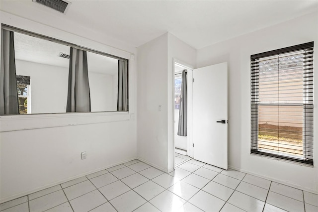 unfurnished room featuring light tile patterned floors, baseboards, and visible vents