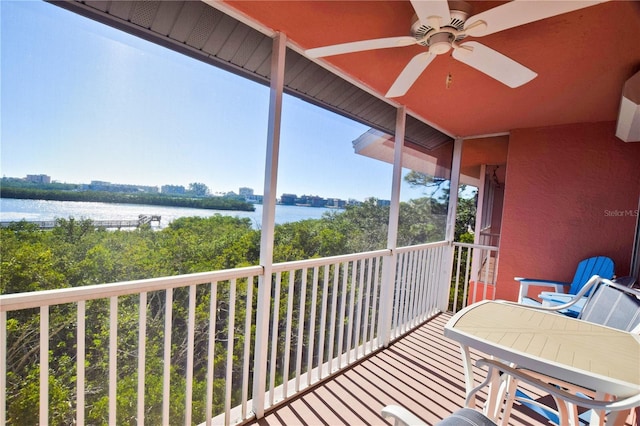 balcony with a water view and a ceiling fan