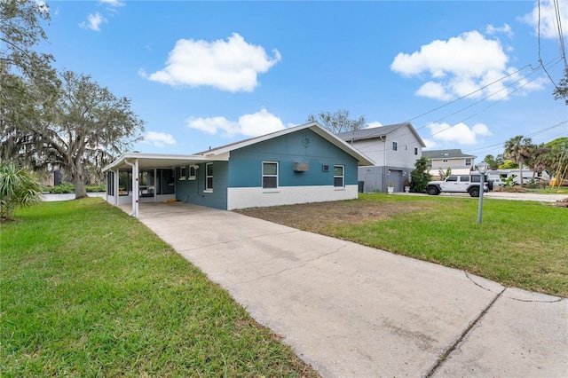 view of front of house featuring a front lawn, an attached carport, concrete driveway, and brick siding