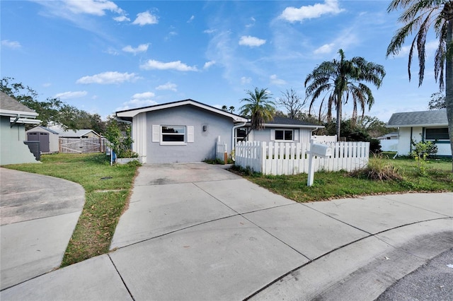 bungalow featuring a fenced front yard and stucco siding