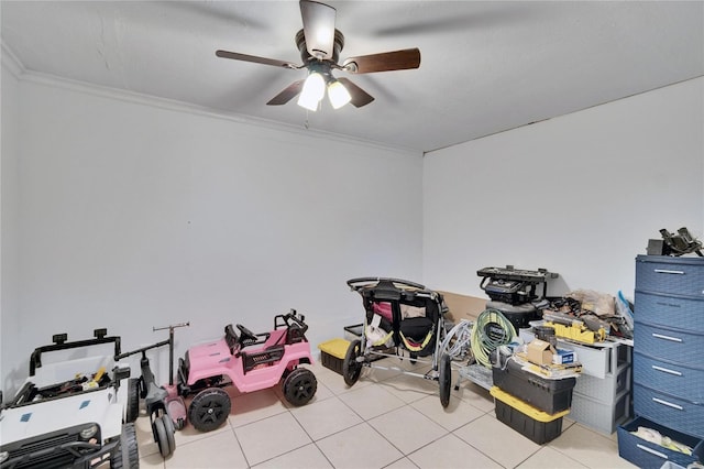 workout room featuring light tile patterned floors, ceiling fan, and ornamental molding