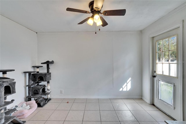 exercise room featuring ceiling fan, ornamental molding, light tile patterned flooring, and baseboards