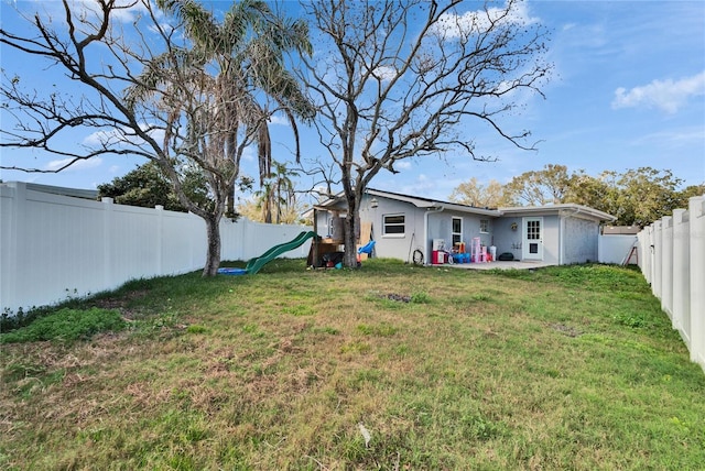 view of yard with a playground and a fenced backyard