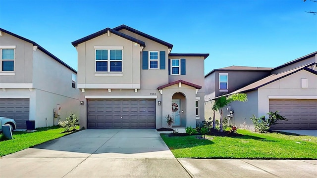 view of front of home featuring concrete driveway, a front lawn, an attached garage, and stucco siding