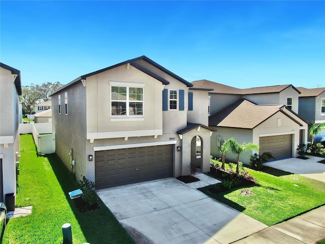 view of front facade featuring driveway, a front yard, and stucco siding