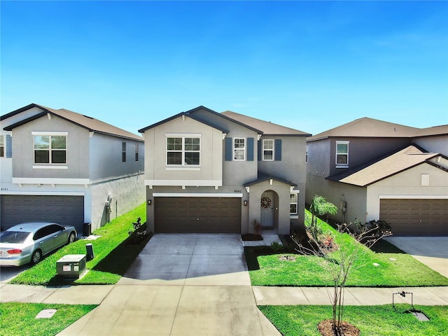 traditional-style house with driveway, a front lawn, an attached garage, and stucco siding