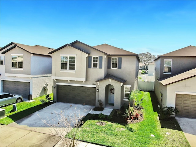 view of front of property featuring a garage, concrete driveway, a front lawn, and stucco siding