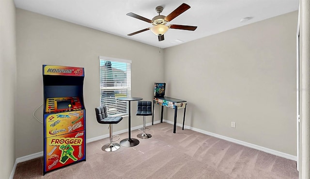 rec room with ceiling fan, baseboards, and light colored carpet