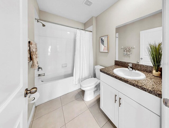 bathroom featuring toilet, vanity, visible vents, tile patterned floors, and shower / bath combo