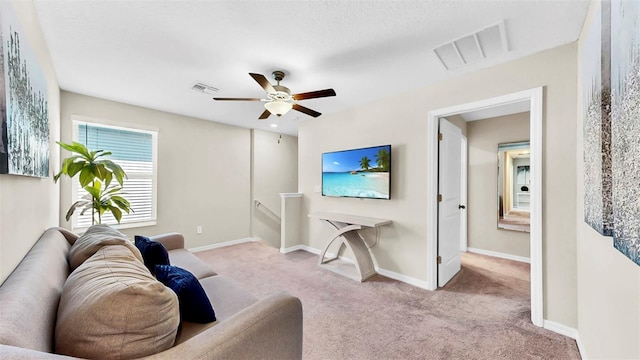 living room featuring a ceiling fan, light colored carpet, visible vents, and baseboards