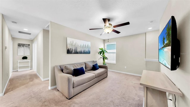 living room featuring baseboards, visible vents, ceiling fan, and light colored carpet