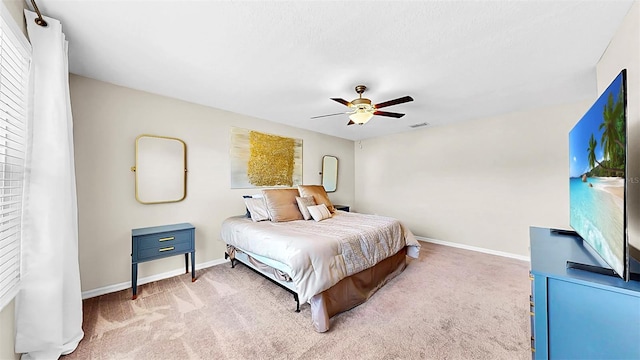 bedroom with baseboards, visible vents, a ceiling fan, and light colored carpet