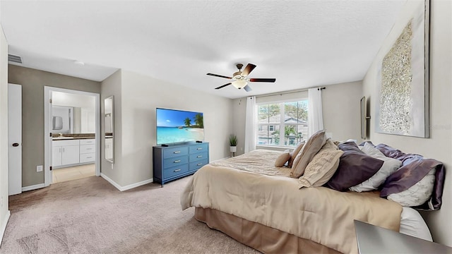 bedroom featuring visible vents, light carpet, connected bathroom, a textured ceiling, and baseboards