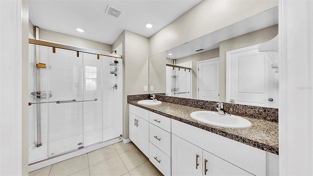 bathroom with double vanity, a sink, visible vents, and tile patterned floors