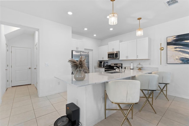 5994 Shiner St, Land O Lakes, FL 34638 - kitchen featuring visible vents, appliances with stainless steel finishes, a kitchen breakfast bar, a peninsula, and pendant lighting