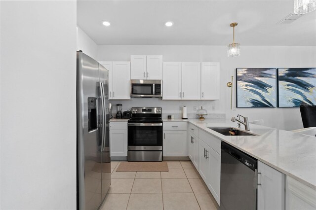 5994 Shiner St, Land O Lakes, FL 34638 - kitchen featuring stainless steel appliances, hanging light fixtures, white cabinets, a sink, and light tile patterned flooring