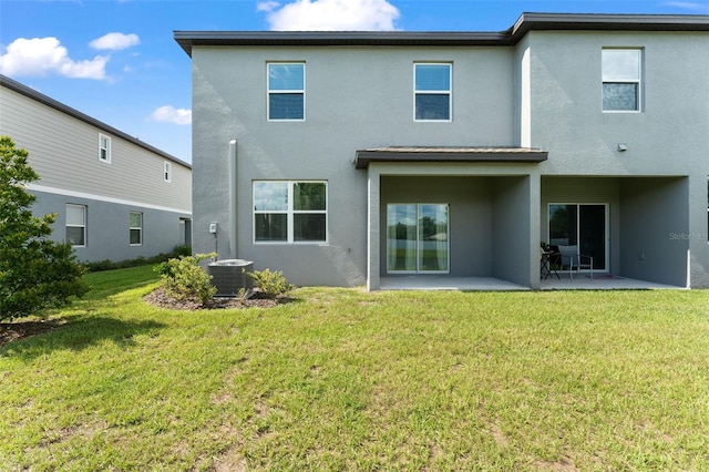 5994 Shiner St, Land O Lakes, FL 34638 - back of property featuring central air condition unit, a lawn, a patio area, and stucco siding