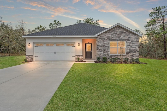 ranch-style home with a yard, stucco siding, concrete driveway, a garage, and stone siding