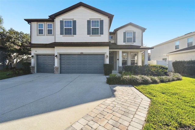 view of front facade featuring a garage, a front yard, concrete driveway, and stone siding