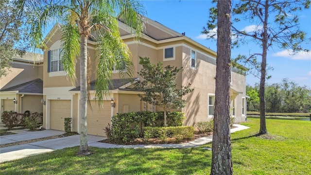 townhome / multi-family property with a garage, concrete driveway, a front lawn, and stucco siding