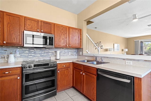 2824 Conch Hollow Dr, Brandon, FL 33511 - kitchen featuring stainless steel appliances, a sink, light countertops, brown cabinets, and decorative backsplash