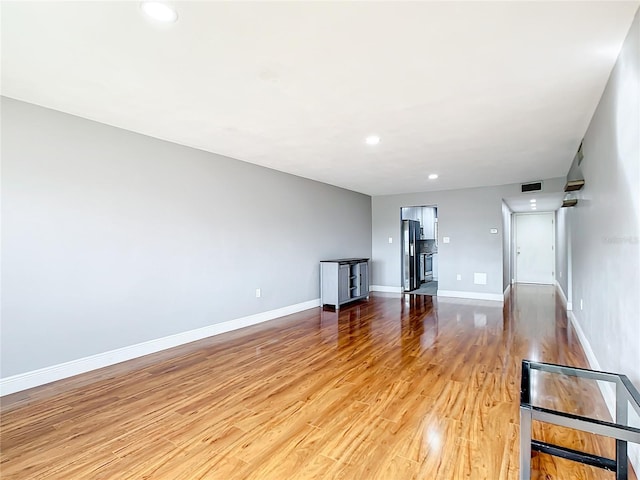 unfurnished living room featuring light wood-style flooring, visible vents, baseboards, and recessed lighting