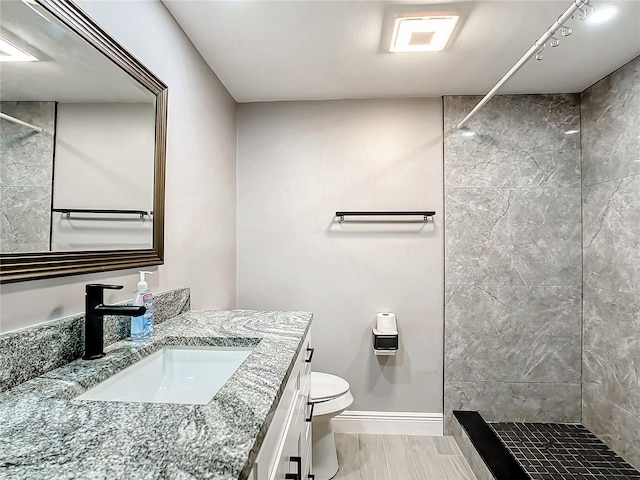 bathroom with a stall shower, visible vents, baseboards, toilet, and vanity