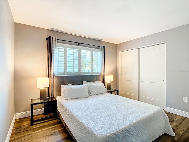 bedroom featuring a closet, baseboards, and wood finished floors