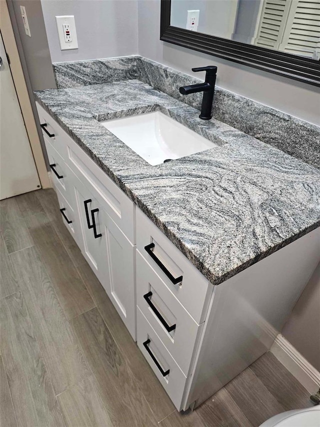 bathroom featuring wood finished floors and vanity