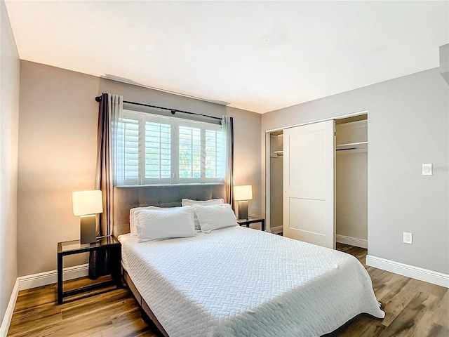 bedroom featuring a closet, wood finished floors, and baseboards