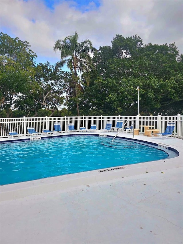 community pool featuring fence and a patio