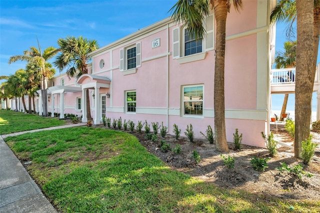 view of front of house featuring a front lawn and stucco siding