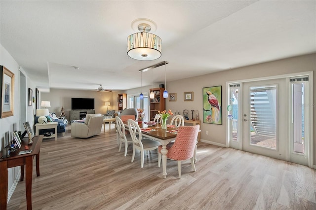 dining space with light wood-style floors, a wealth of natural light, and a ceiling fan