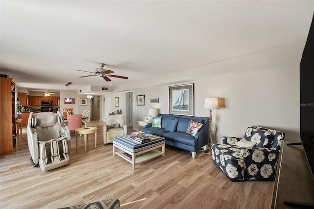 living room featuring light wood-type flooring and a ceiling fan