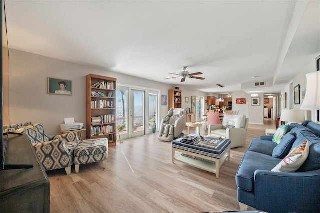 living area with ceiling fan, light wood-type flooring, and visible vents