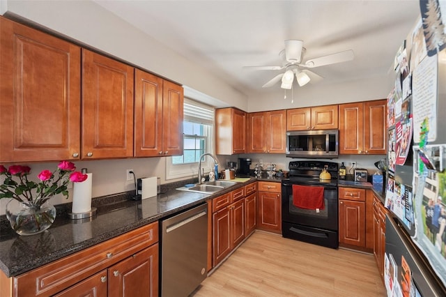 kitchen featuring stainless steel appliances, light wood-style floors, brown cabinetry, a sink, and ceiling fan