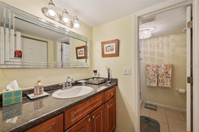 bathroom with vanity, baseboards, and tile patterned floors